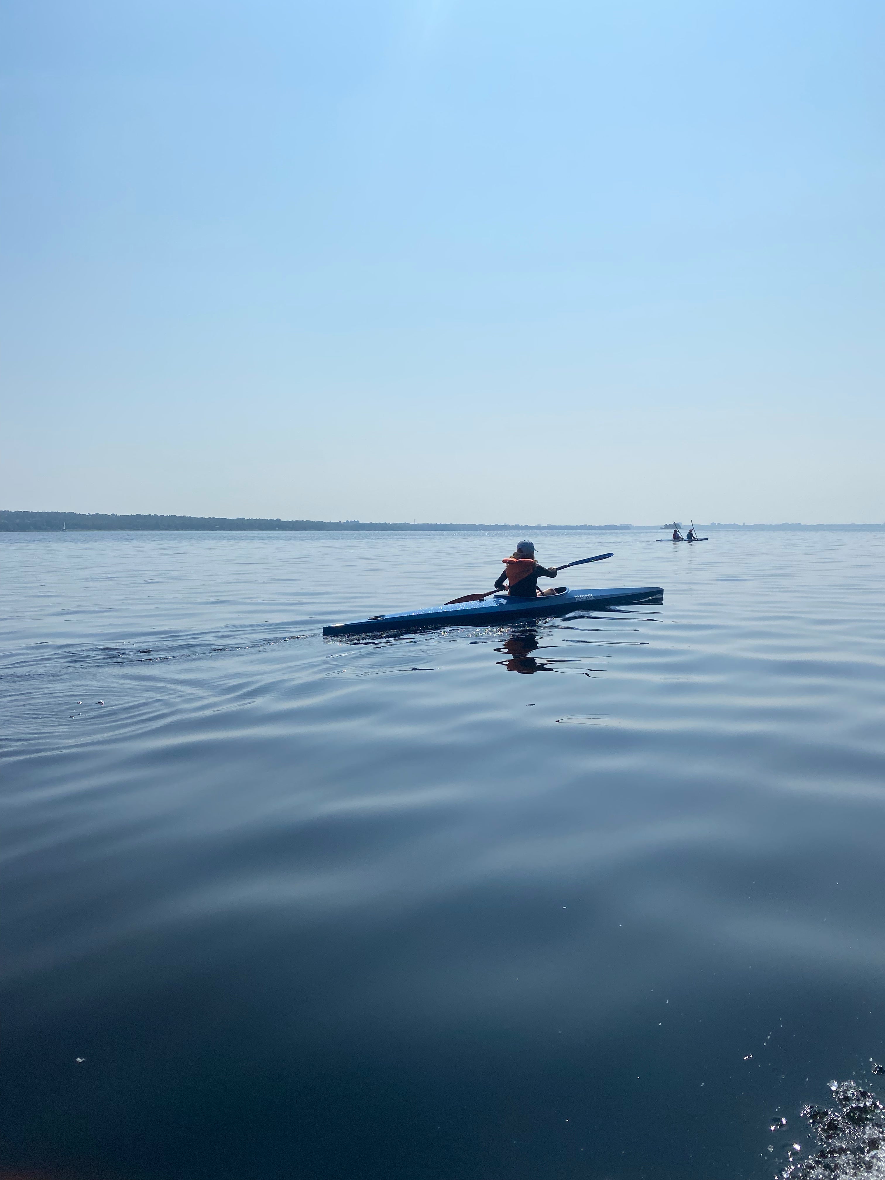 I2C athlete paddling K1 on a flat unny and seemingly hot day on the Ottawa River.