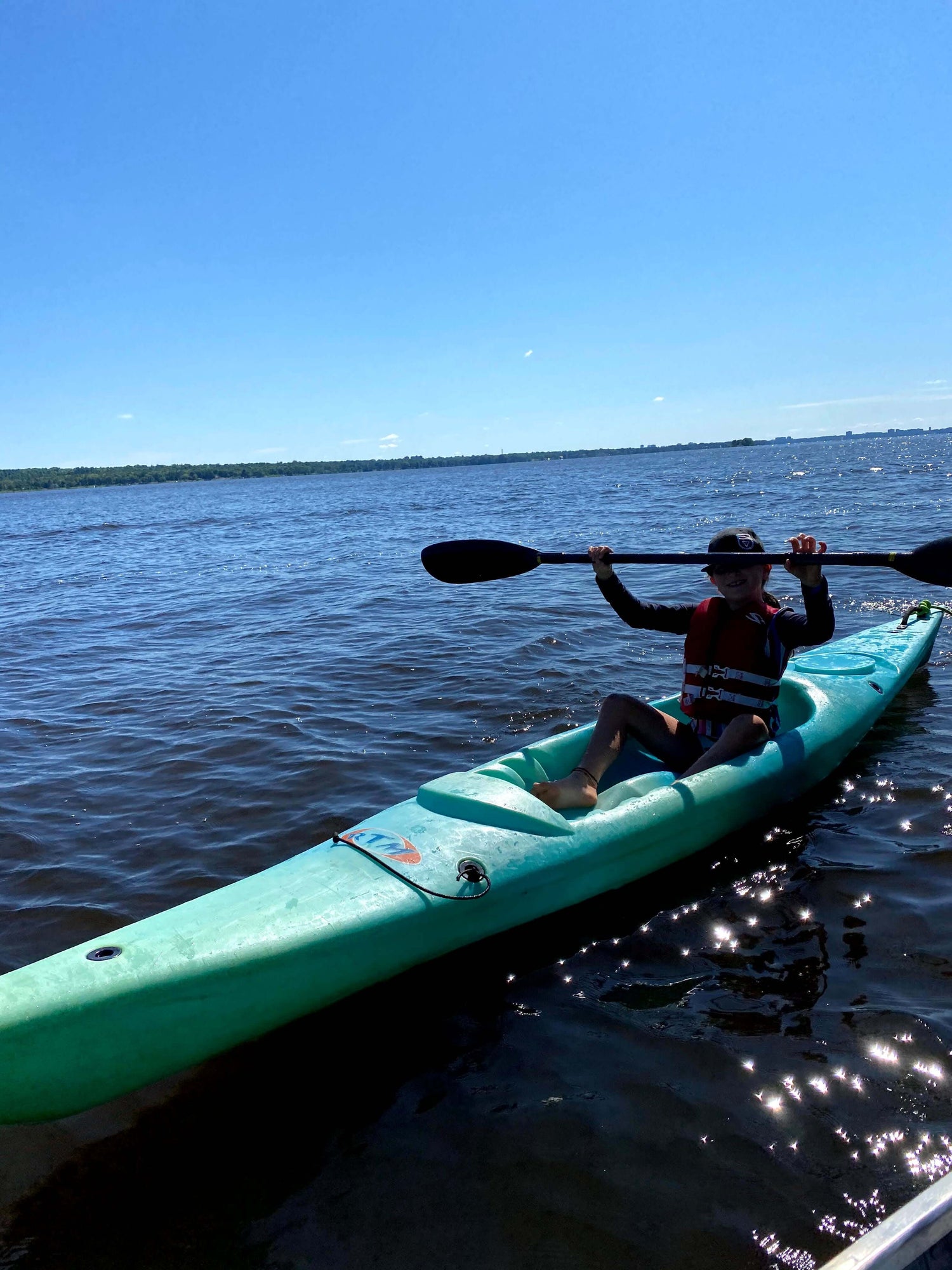 Female camper has fun in a rec kayak on a beautiful sunny day.