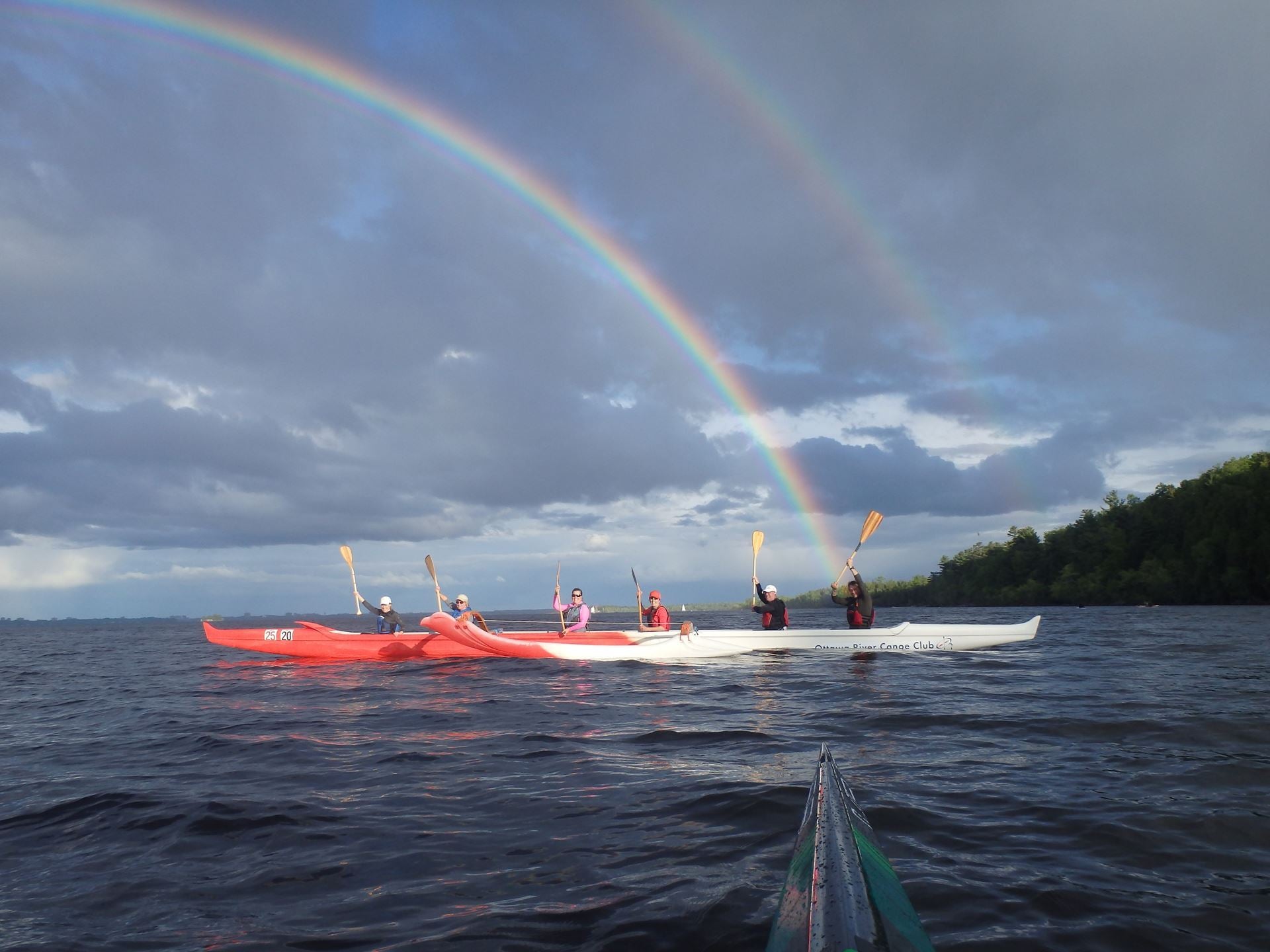 OC Rec participants paddle under a cloud but beautiful rainbow