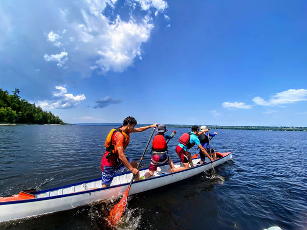 I2C U12 male athletes paddle away from dock in C4.