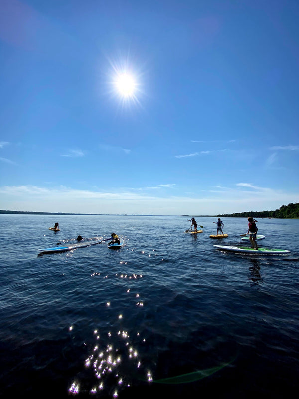 CK campers enjoy the beautiful river on SUP while some swim from the SUP.